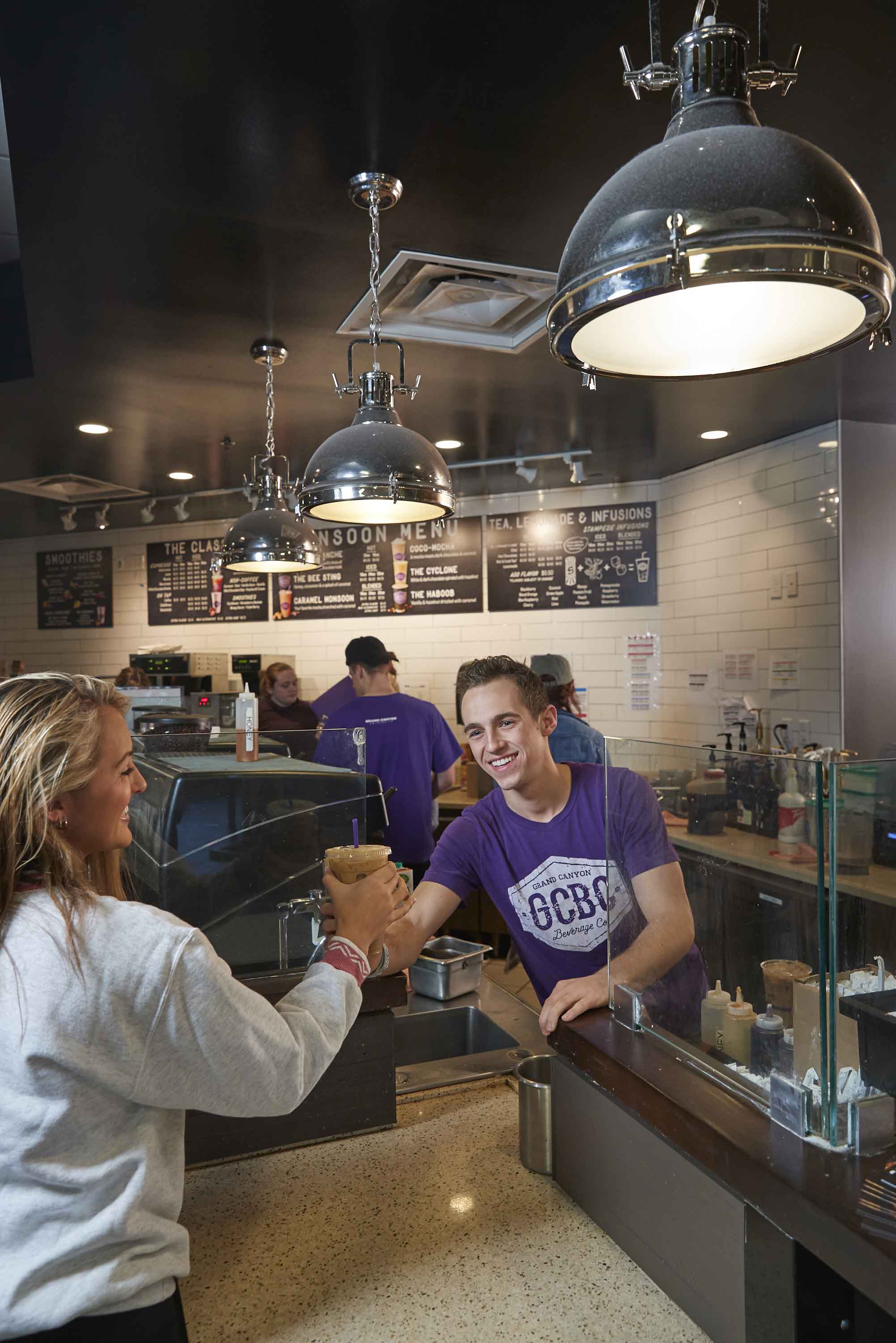 GCBC Barista serving a coffee drink